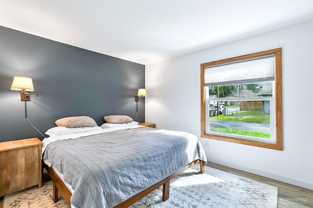 bedroom featuring baseboards and wood finished floors