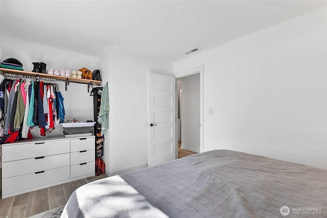 bedroom featuring wood finished floors and visible vents