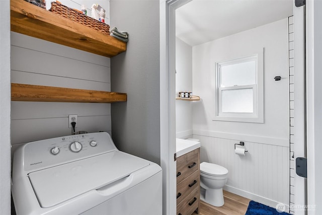 laundry room with washer / dryer, light wood-style flooring, wainscoting, and laundry area