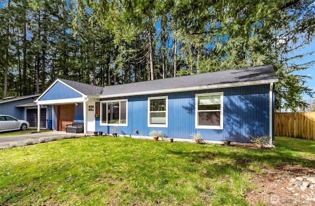 ranch-style house featuring concrete driveway, a front yard, and fence