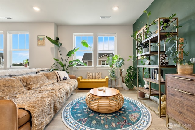 living area with visible vents, recessed lighting, and wood finished floors