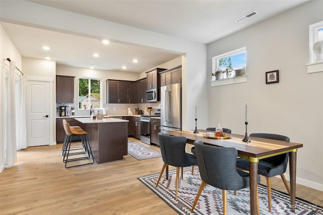 dining room featuring light wood finished floors, visible vents, recessed lighting, and baseboards