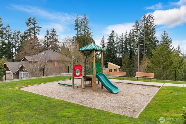 community jungle gym with a yard and fence