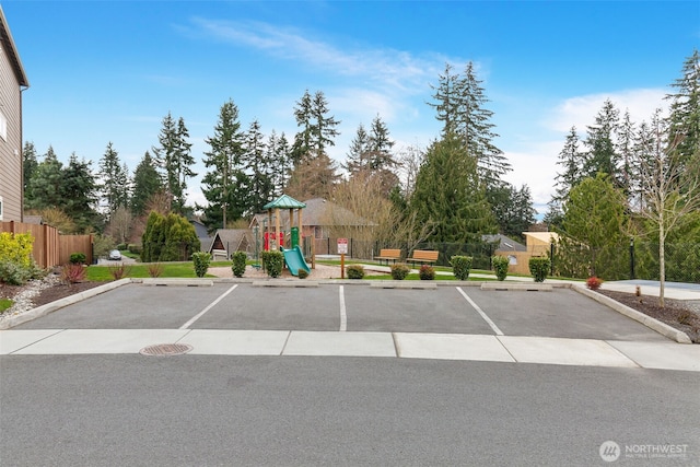 uncovered parking lot with playground community and fence