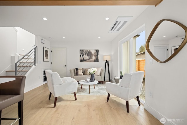 living area with recessed lighting, stairs, and light wood finished floors