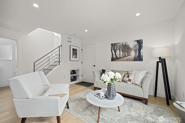 living room with stairway, recessed lighting, light wood-style floors, and baseboards