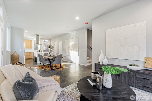 living area featuring finished concrete floors, recessed lighting, stairway, and baseboards