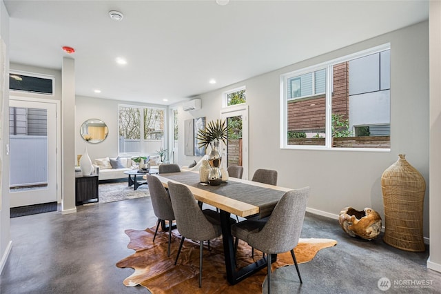 dining area with recessed lighting, concrete flooring, a wall mounted AC, and baseboards