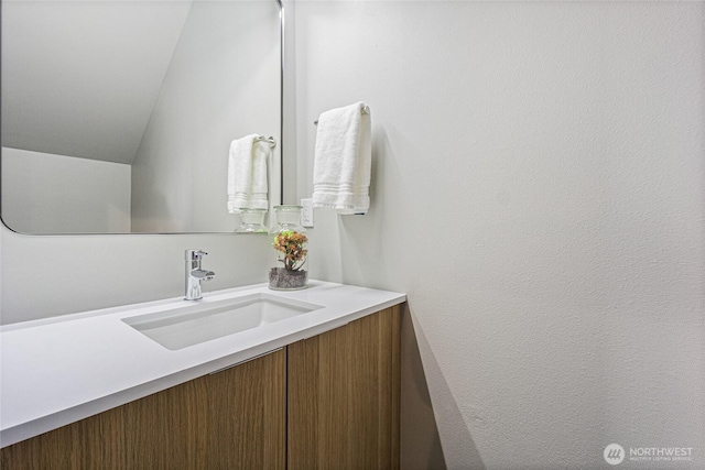 bathroom featuring lofted ceiling and vanity