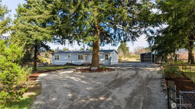 single story home with an outdoor structure, fence, and driveway