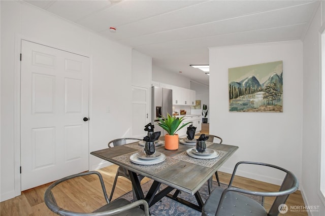 dining room with light wood-style floors and baseboards