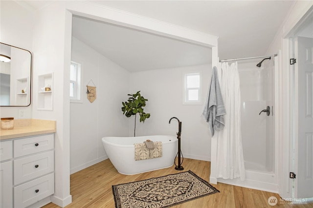 full bath with a soaking tub, curtained shower, vanity, and wood finished floors