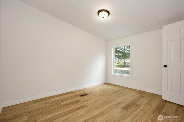 spare room featuring visible vents, baseboards, and light wood-style floors