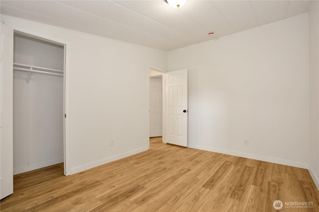 unfurnished bedroom featuring a closet, baseboards, and light wood-style floors