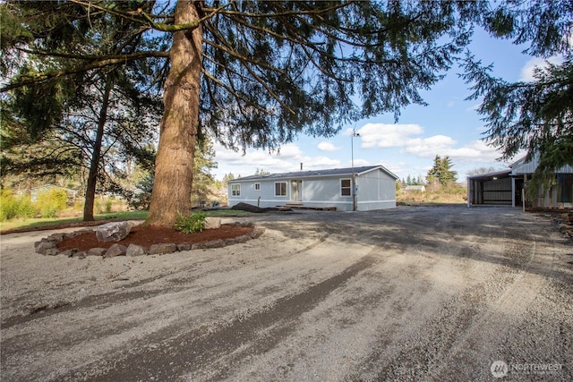 view of front of property with an outbuilding, driveway, and a pole building