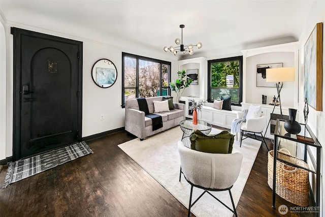 living room with baseboards, plenty of natural light, a notable chandelier, and wood finished floors