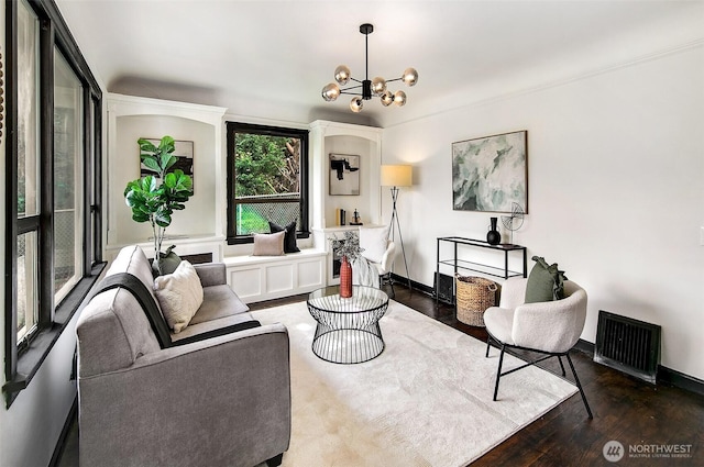 living room featuring a chandelier, baseboards, and wood finished floors