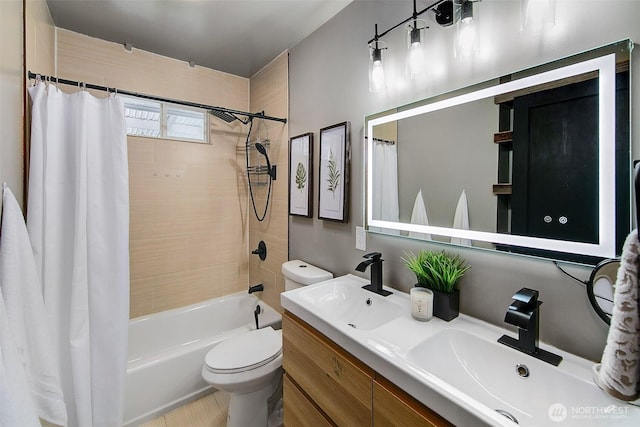 bathroom featuring double vanity, toilet, shower / bath combo with shower curtain, and a sink