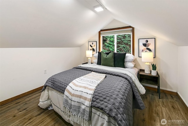 bedroom with baseboards, lofted ceiling, and wood finished floors