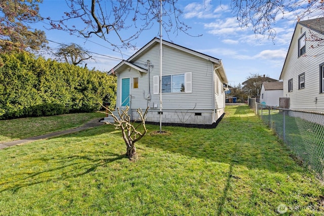 view of front facade with a front lawn, fence, and crawl space