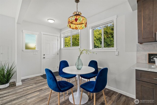 dining space with baseboards and wood finished floors