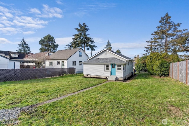 back of house featuring crawl space, a lawn, entry steps, and a fenced backyard