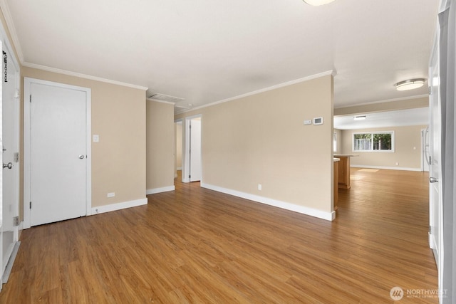 empty room with crown molding, baseboards, and light wood-type flooring