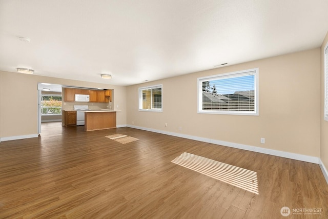 unfurnished living room featuring visible vents, baseboards, and dark wood-style flooring