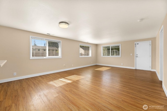 spare room with light wood-style flooring, visible vents, and baseboards