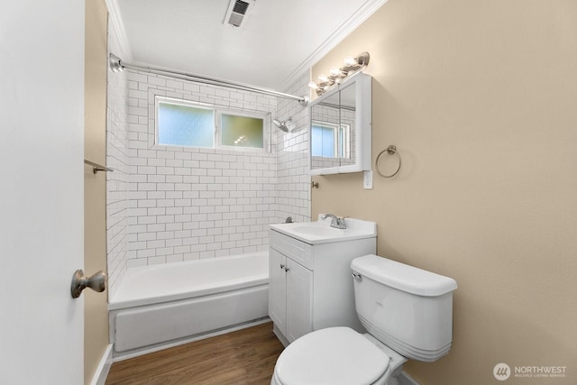 bathroom with wood finished floors, visible vents, ornamental molding, bathing tub / shower combination, and toilet