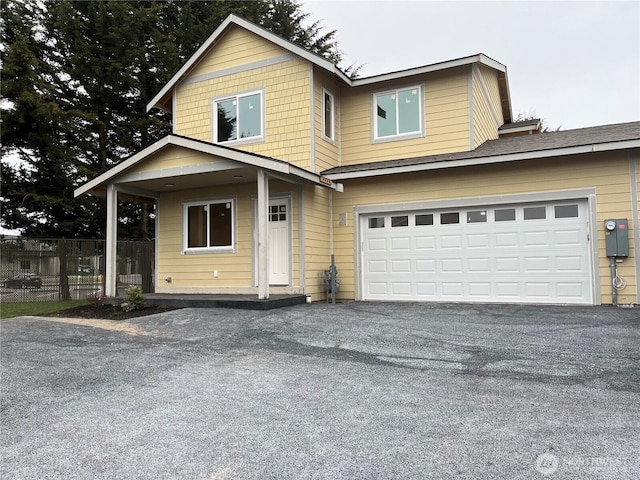 view of front of home with an attached garage, fence, and driveway