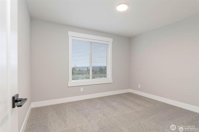 carpeted spare room featuring baseboards