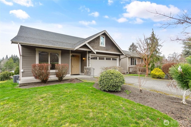 view of front of property featuring driveway, a front yard, an attached garage, and a shingled roof