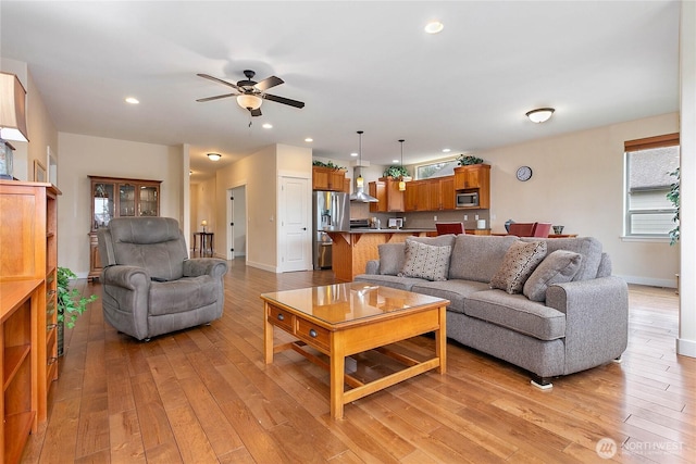 living room featuring recessed lighting, baseboards, light wood-type flooring, and a ceiling fan