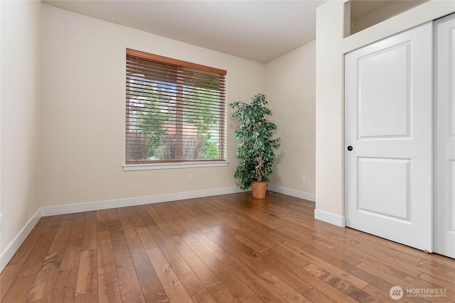 unfurnished room featuring baseboards and light wood-style flooring