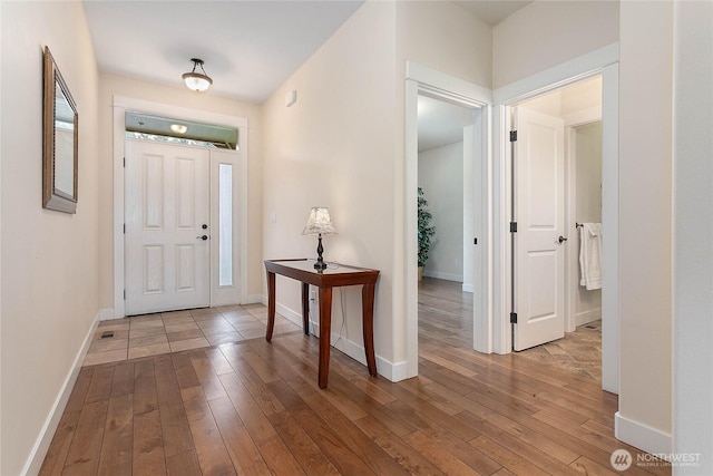 foyer featuring baseboards and hardwood / wood-style flooring