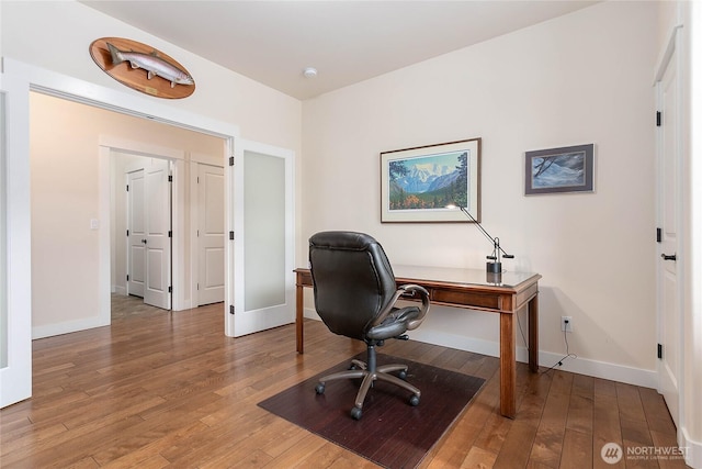 home office with baseboards and wood-type flooring