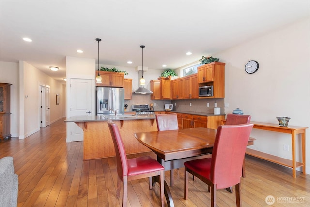 dining room featuring light wood-style flooring, recessed lighting, and baseboards