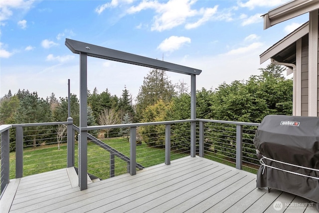 wooden deck with a lawn and a grill