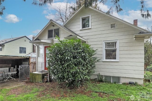 back of house with a patio, fence, and a chimney