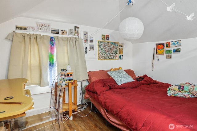 bedroom featuring wood finished floors and vaulted ceiling