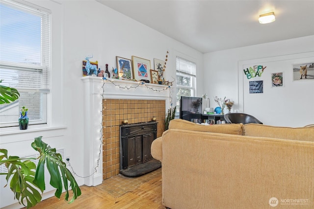 living area featuring a brick fireplace and light wood-style flooring