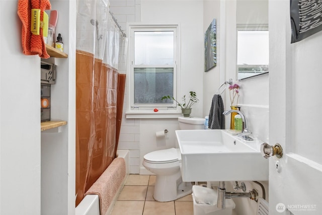 bathroom featuring toilet, shower / bath combo, a sink, radiator heating unit, and tile patterned flooring