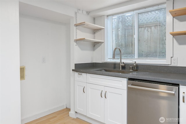 kitchen featuring open shelves, a sink, white cabinets, dishwasher, and dark countertops