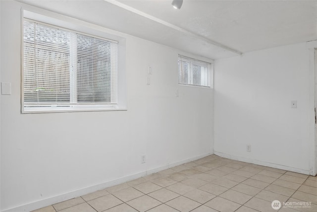 unfurnished room with light tile patterned floors and baseboards