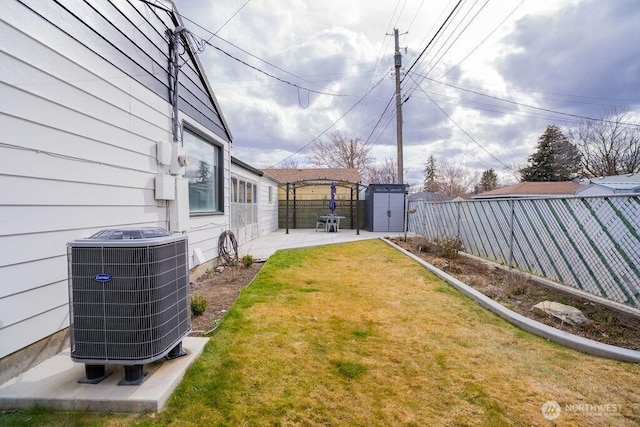 view of yard featuring central air condition unit, an outdoor structure, a fenced backyard, and a patio area