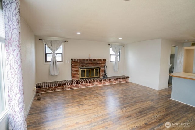 unfurnished living room featuring recessed lighting, wood finished floors, and a fireplace