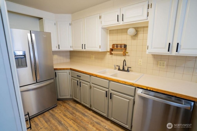 kitchen featuring a sink, stainless steel appliances, dark wood-style floors, and light countertops