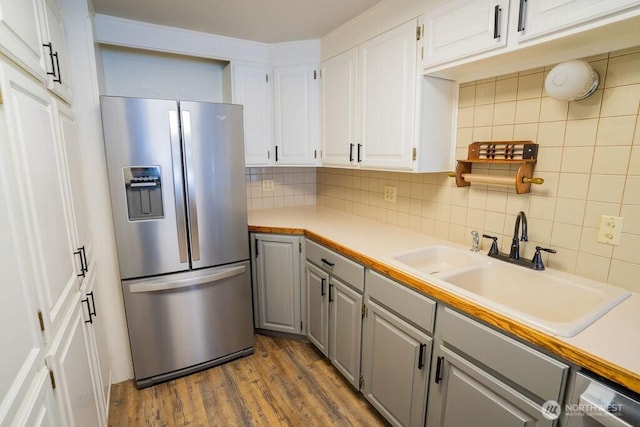 kitchen with stainless steel fridge with ice dispenser, decorative backsplash, gray cabinets, dark wood-style floors, and a sink