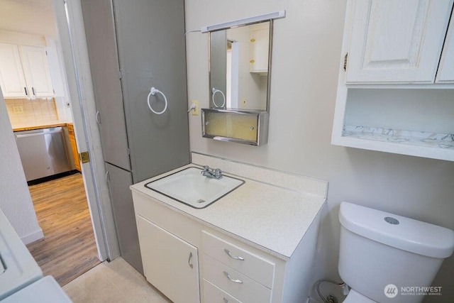 bathroom with decorative backsplash, toilet, vanity, and wood finished floors